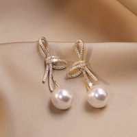Boucles d'oreilles en perles avec noeud brillant en or